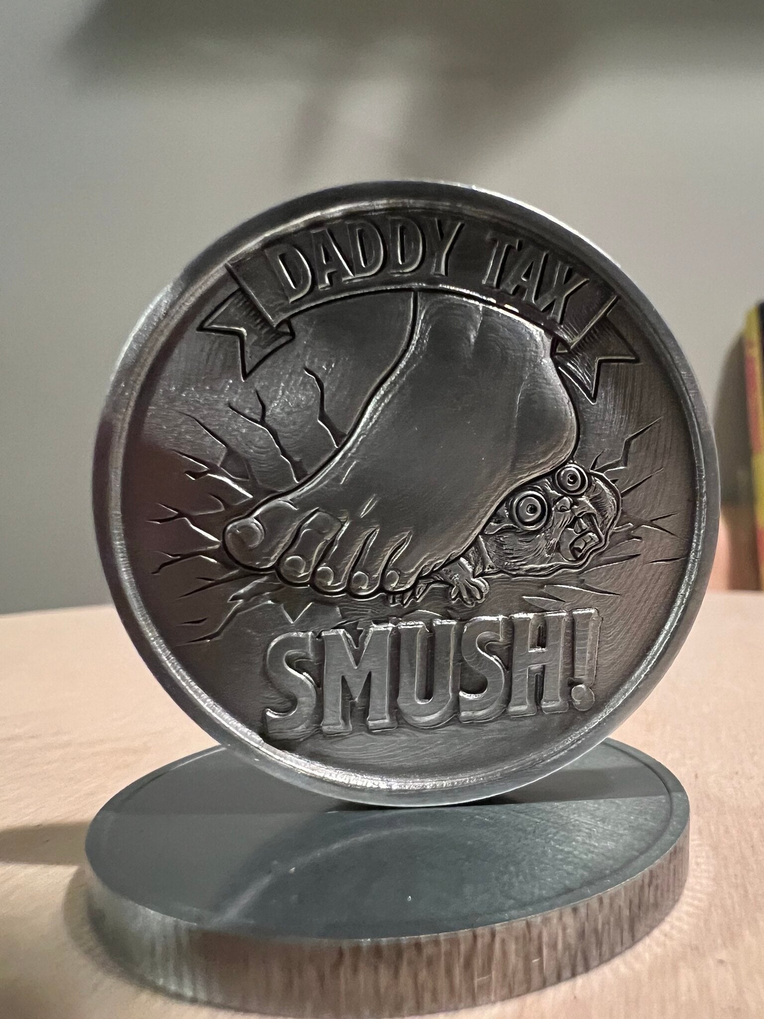 Daddy Tax coin in antique silver on display stand